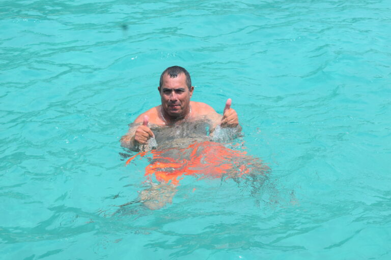 imagem de uma pesoa gesticulando de forma alegre e positiva e boiando no mar
