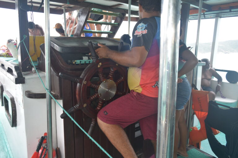 Imagem do capitão do barco segurando o timão